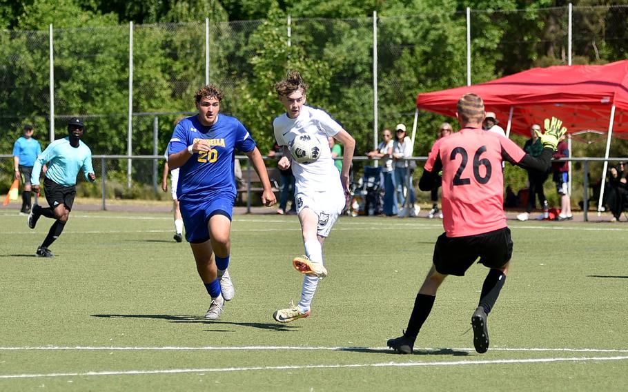 Alconbury midfielder Aaron Dudley chips Sigonella goalkeeper Lasse Nestler for a goal during the second day of pool-play action at the 2025 Division III DODEA European championships on May 20, 2025, at Rothenborn Stadion in Landstuhl, Germany.