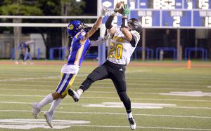 American School In Japan's Noa Grasse snags one of five Mustangs interceptions, against Yokota's Royce Canta.