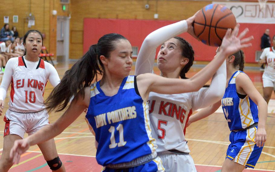 E.J. King's Maliwan Schinker tries to shoot against Yokota's Sierra Light during Friday's DODEA-Japan girls basketball game. The Cobras won 60-39.