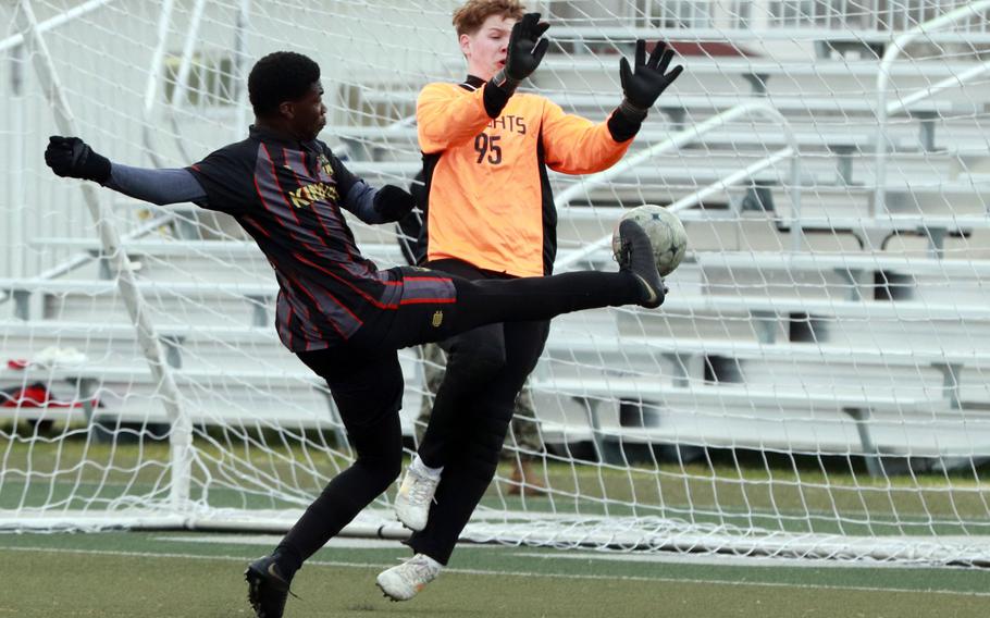 Nile C. Kinnick's Koboyo Awesso boots the ball against Christian Academy Japan keeper Lewis Hersheberger. The Red Devils won Tuesday's Kanto Plain boys soccer match 7-1.