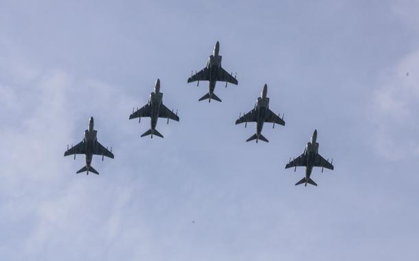 Five AV-8B Harrier II aircraft fly in formation.