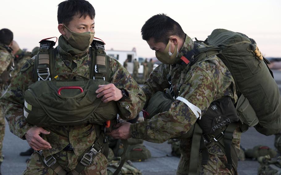 Japan Ground Self-Defense Force troops prepare their parachuting gear at Yokota Air Base, Japan, Tuesday, Jan. 25, 2022.
