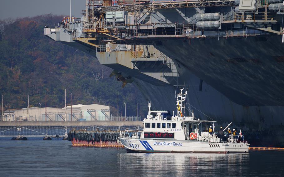 Teams aboard a Japan Coast Guard vessel collect water samples near the USS Ronald Reagan during an annual drill that simulates a radiation leak from the aircraft carrier, Wednesday, Dec. 15, 2021.