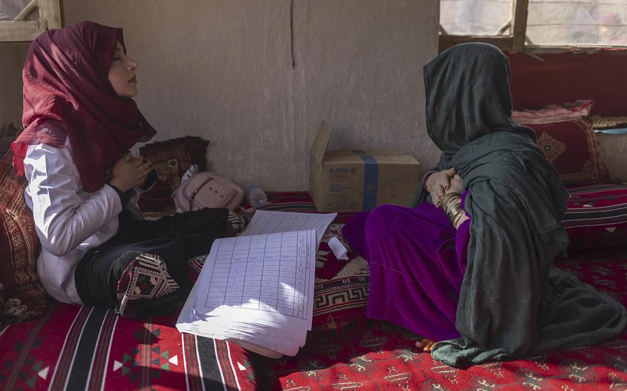 A worker helps a woman with a breathing exercise to ease her anxiety at a mobile health clinic in Kabul Province, earlier in October 2022.