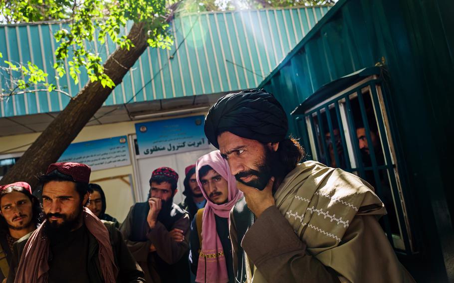 Mawlawi Shaker, far right, the new chief of this city's Police District 10, listens to the plight of a passerby at PD10, in Kabul, Afghanistan, on Sept. 2, 2021. 