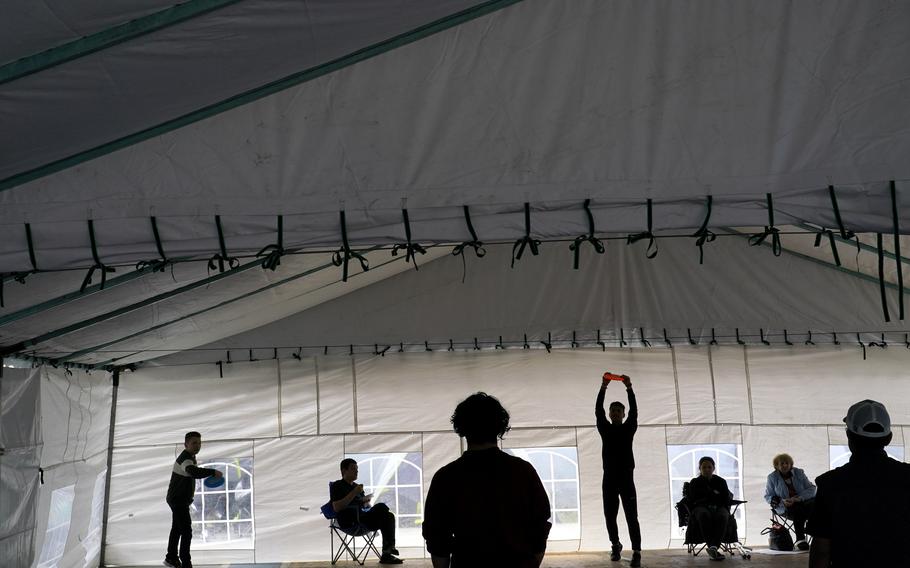 Ukrainian refugees play with frisbees as they wait in front of a gymnasium April 5, 2022, in Tijuana, Mexico. The Biden administration is allowing thousands of Ukrainians who fled their homeland when Russia invaded a year ago to stay in the United States longer. 