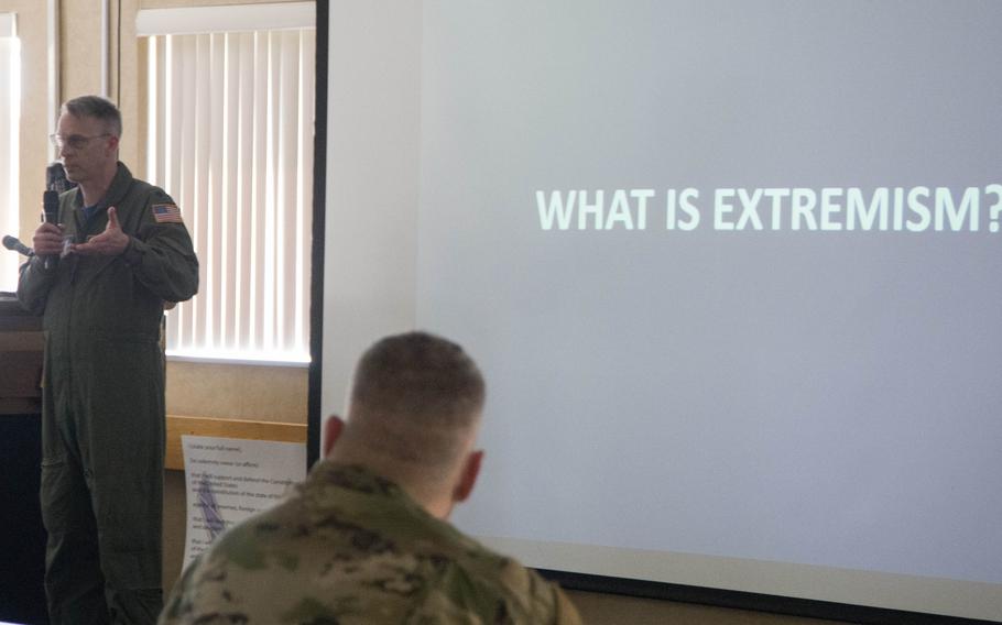 Air Force Lt. Col. Kevin Culbert defines extremism during a briefing in Martinsburg, W.Va., as part of a 2021 stand-down ordered by Defense Secretary Lloyd Austin. A recent study by the Institute for Defense Analyses found that there is no evidence to support the notion that violent extremism is widespread among the troops, but that extremist groups have been known to target veterans.