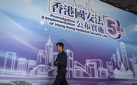 A pedestrian walks past a banner celebrating the 5th Anniversary of the implementation of Hong Kong National Security Law in Hong Kong, Saturday, June 21, 2025. (AP Photo/Chan Long Hei)