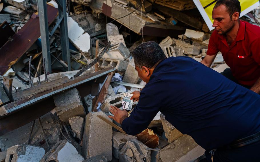 Samir Mansour gathers books from the rubble that was once his bookstore, a Gaza cultural lodestar, destroyed in an Israeli bombardment during the last escalation, which lasted 11 days between Israel and Gaza military factions, in Gaza City on Wednesday, May 26, 2021.