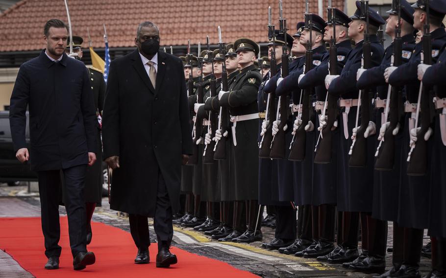 Defense Secretary Lloyd Austin is welcomed  by Lithuanian acting defense minister Garbrielius Landsbergis, left, during a ceremony in Vilnius, Lithuania, Feb. 19, 2022. Austin arrived to meet with Baltic leaders concerned about Russia's military buildup near Ukraine's borders.