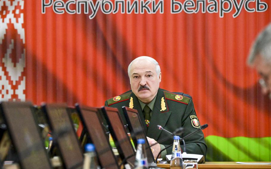 Belarusian President Alexander Lukashenko attends a meeting with top level military officials in Minsk, Belarus, on Nov. 22, 2021. A human rights group in Belarus says authorities have raided the homes of dozens of journalists and activists. The Viasna human rights center reported that independent journalists, human rights advocates and activists in at least nine large Belarusian cities had phones and computers seized during the searches and were interrogated. 