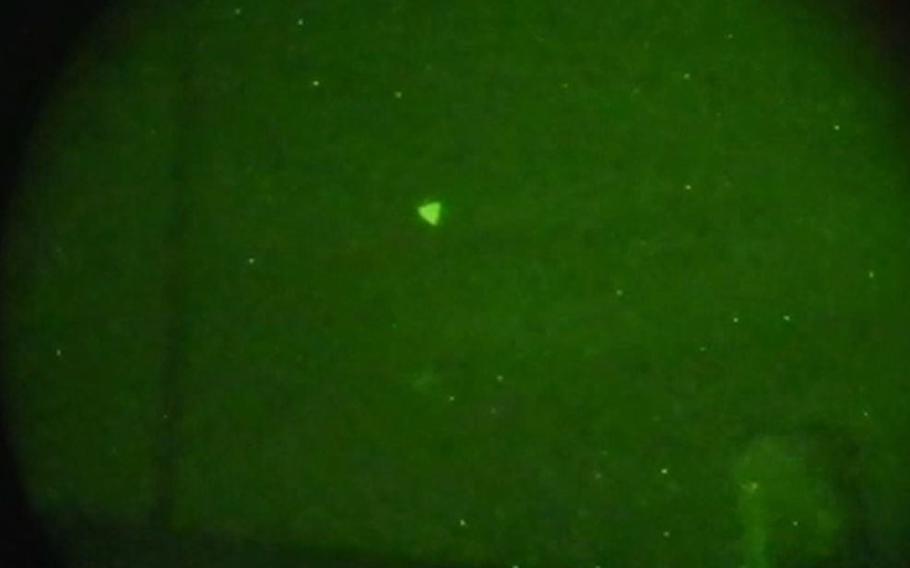 This is a Navy image of an unidentified aerial phenomena, commonly known as a UFO, captured during naval exercises off the East Coast of the United States in early 2022. The image was captured through night vision goggles and a single lens reflex camera. Based on additional information and data from other sightings, the UFO in this image was reclassified as unmanned aerial systems.