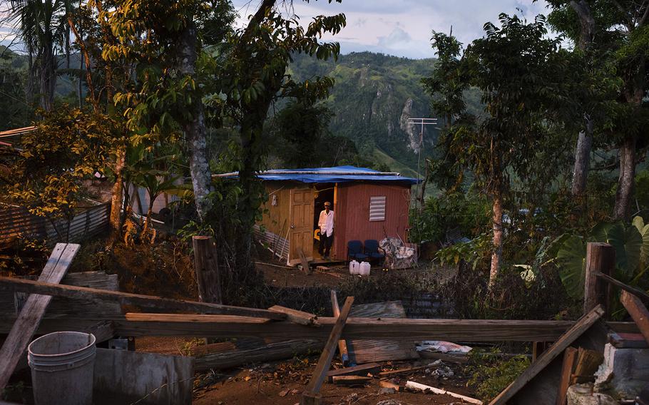 As the sun sets, Carlos Fernandez, 90, stands in the doorway of his shack, down a steep, winding road on a remote mountainside in Villalba, Puerto Rico.