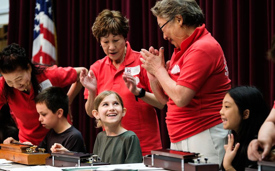 Students learn how to play a Japanese stringed instrument called a taisho-koto.
