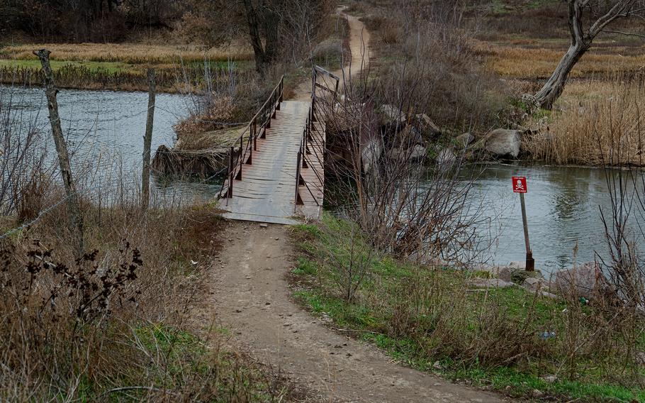 The pedestrian bridge over the Kalmius River and the road toward Staromarivka, in the “gray zone” area between front lines.