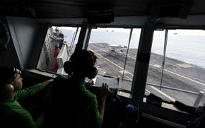 Crew on the primary flight control deck watch as an E-2 Hawkeye lands aboard the USS George Washington (CVN-73) off the coast of Florida on September 14, 2023. (Billy Schuerman / The Virginian-Pilot)