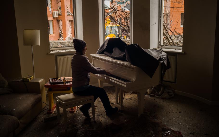 The mother of Karina plays the piano in the living room after the blast.