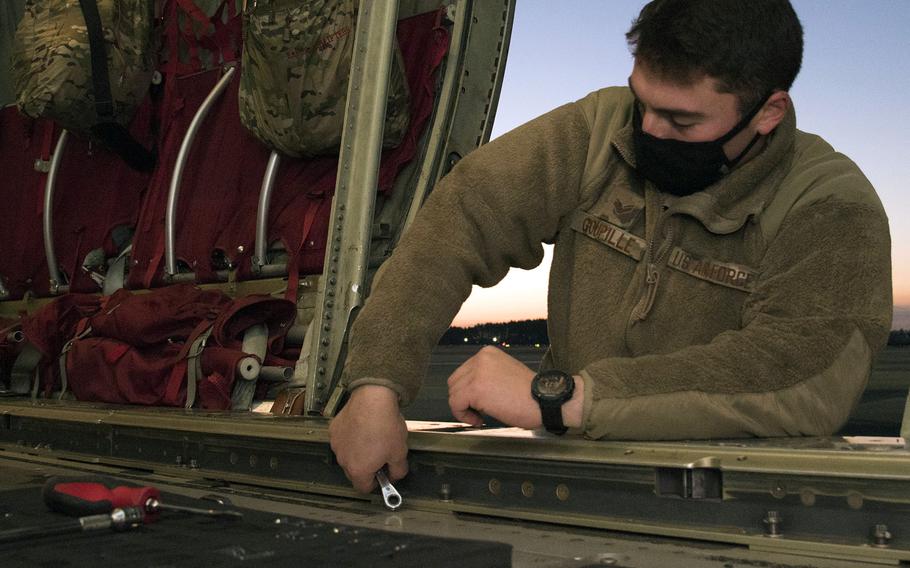 Senior Airman Dustin Goupille, a flying crew chief assigned to the 374th Airlift Wing, works on a C-130J Super Hercules ahead of the Airborne 22 exercise at Yokota Air Base, Japan, Jan. 25, 2022.