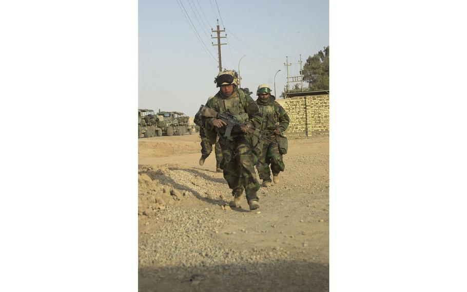 Open space is dead space. Marines rush for cover during a raid at Al Fahr, Iraq.      