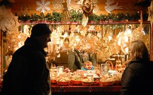 Bad Hersfeld, Germany, Dec. 1, 2006: The child of one of the vendors at the Bad Hersfeld Christmas market is full of holiday cheers as shoppers pass by the stand.

Check out Stars and Stripes' list of German holiday markets here.
https://europe.stripes.com/travel/2023-german-christmas-market-directory.html

META TAGS: German Christmas market; holidays; straw christmas ornaments; tree ornaments; 