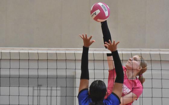 Aviano's Addison Krajicek skies well above the net to spike the ball Saturday, Oct. 14, 2023, while Rota's Pamela Munoz defends. The Admirals won in five sets.

Kent Harris/Stars and Stripes