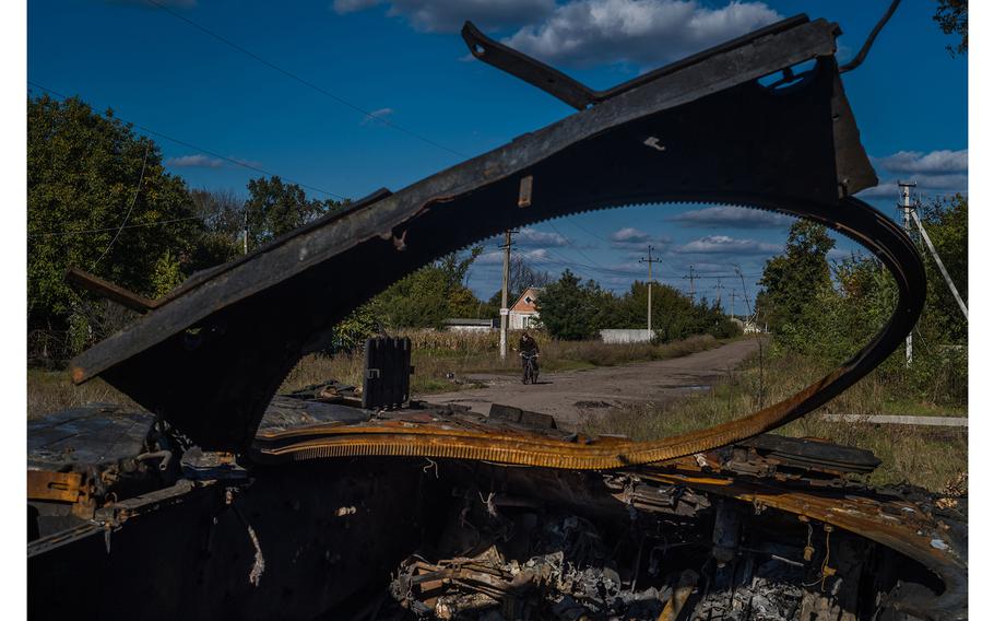 A bicyclist approaches a destroyed Russian tank last October in Pisky Radkivsky in the Kharkiv region of eastern Ukraine. 