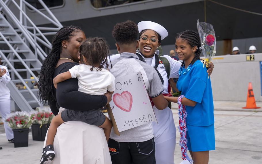 A sailor hugs her loved ones.