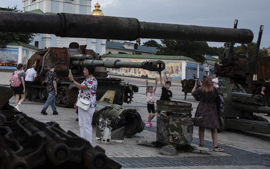 People take selfies of themselves by destroyed Russian military equipment at an open air exhibition on Mykhailivska Square in Kyiv, Ukraine, on Aug. 1, 2022. 