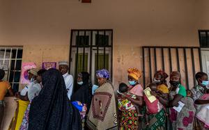 Women and children wait in line for malaria medication at a health center in Nametil, Mozambique, in 2023. 
