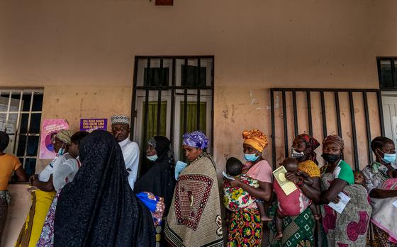 Women and children wait in line for malaria medication at a health center in Nametil, Mozambique, in 2023. 
