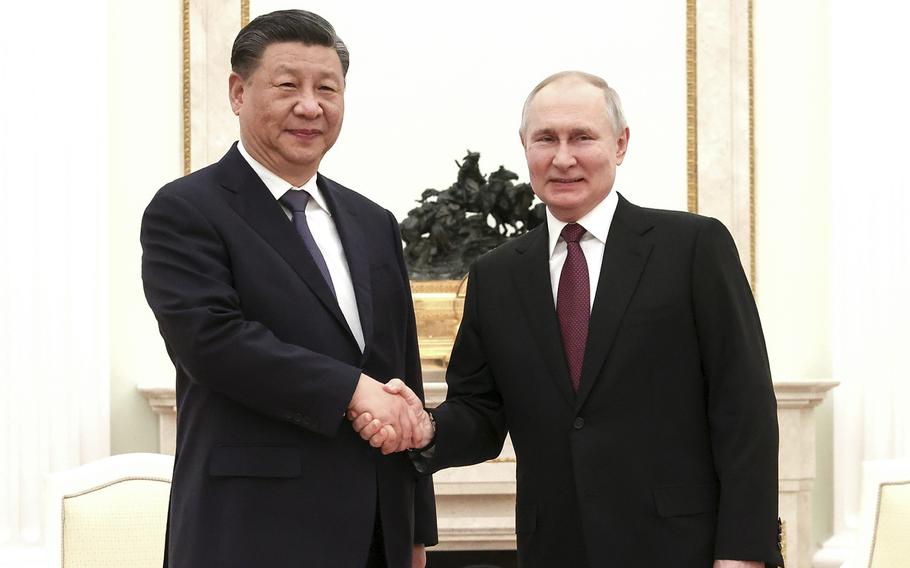 In this handout photo released by Russian Presidential Press Office, Russian President Vladimir Putin, right, and Chinese President Xi Jinping shake hands prior to their talks at the Kremlin in Moscow, March 20, 2023.