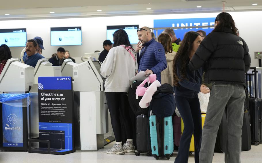 Travelers with their luggage check in for their flights.