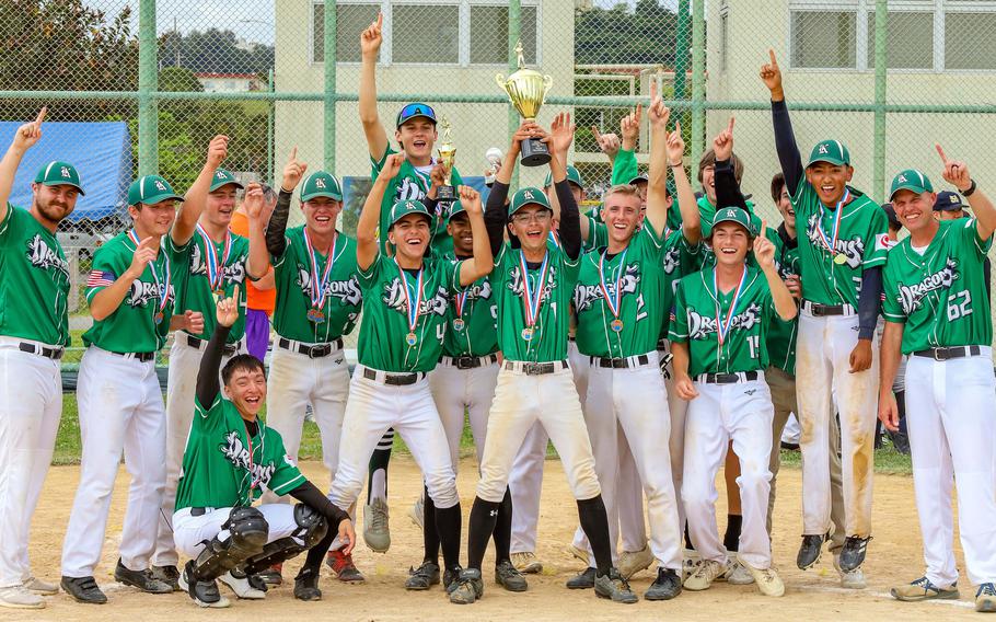 Kubasaki's players and coaches celebrate with the championship hardware.