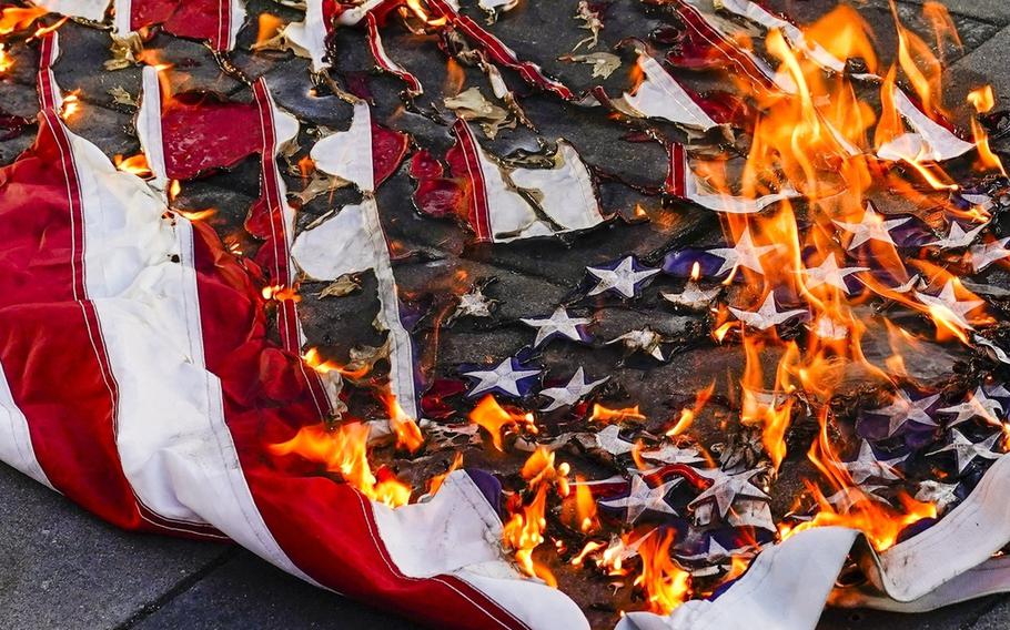 An American flag is burned.