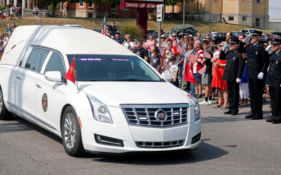 A hearse carrying the body of Marine Corps Cpl. Humberto "Bert" Sanchez pauses during his funeral procession at the corner of 8th Street and East Market Street on Sept. 12, 2021, in Logansport, Ind.