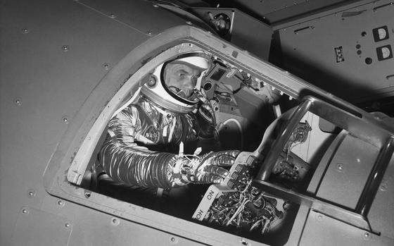 FILE - In this Jan. 11, 1961 file photo, Marine Lt. Col. John Glenn reaches for controls inside a Mercury capsule procedures trainer as he shows how the first U.S. astronaut will ride through space during a demonstration at the National Aeronautics and Space Administration Research Center in Langley Field, Va. In 2021, as more companies start selling tickets to space and the cosmos opens for travel like never before, a question looms above all others. Who gets to call themselves an astronaut? (AP Photo/File)