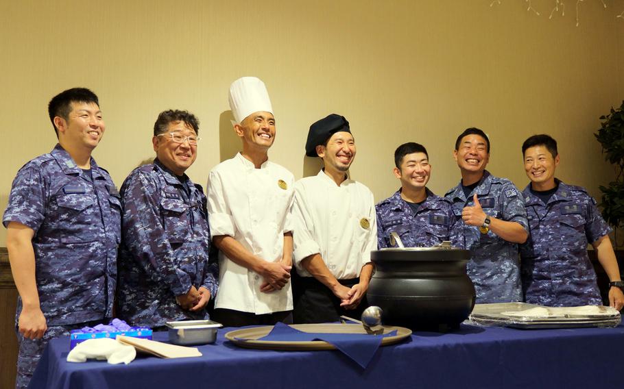 Culinary specialists from the Japan Maritime Self-Defense Force pose with officers during a tasting session for Kizuna 111 curry at Club Alliance on Yokosuka Naval Base, Japan, July 21, 2023. 
