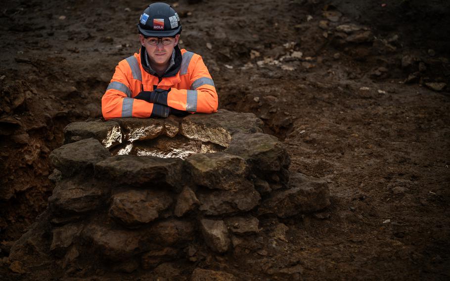 A site manager is seen by one of several wells, which archaeologists called “beautifully preserved,” near South Northamptonshire, England. 
