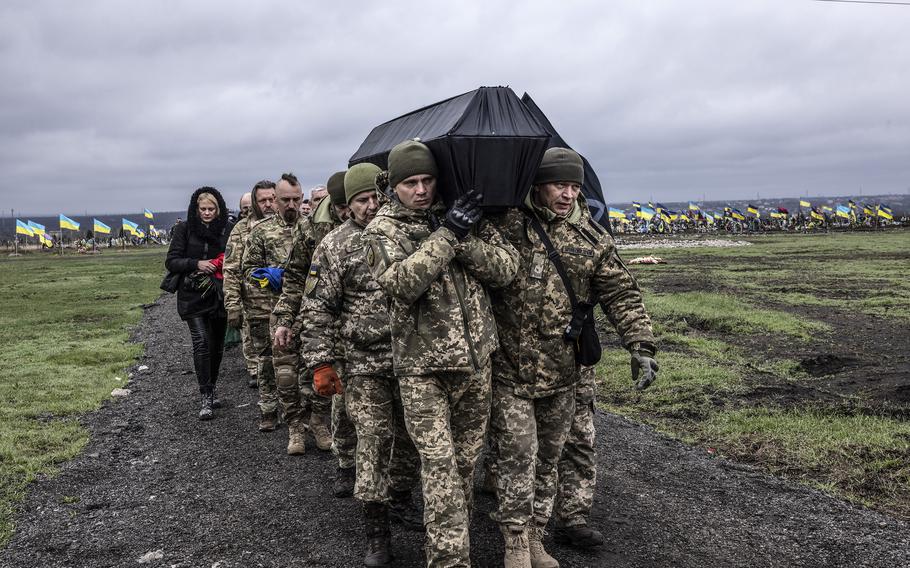 Ukrainian troops carry the coffin of a fellow soldier killed by mortar fire outside the city of Bakhmut, Ukraine, in early April 2023.