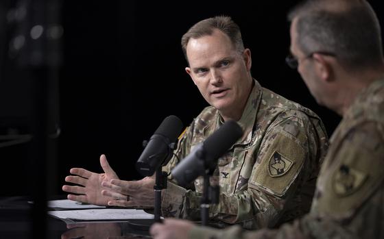 Wright in uniform and seated, speaking into a microphone during a podcast.