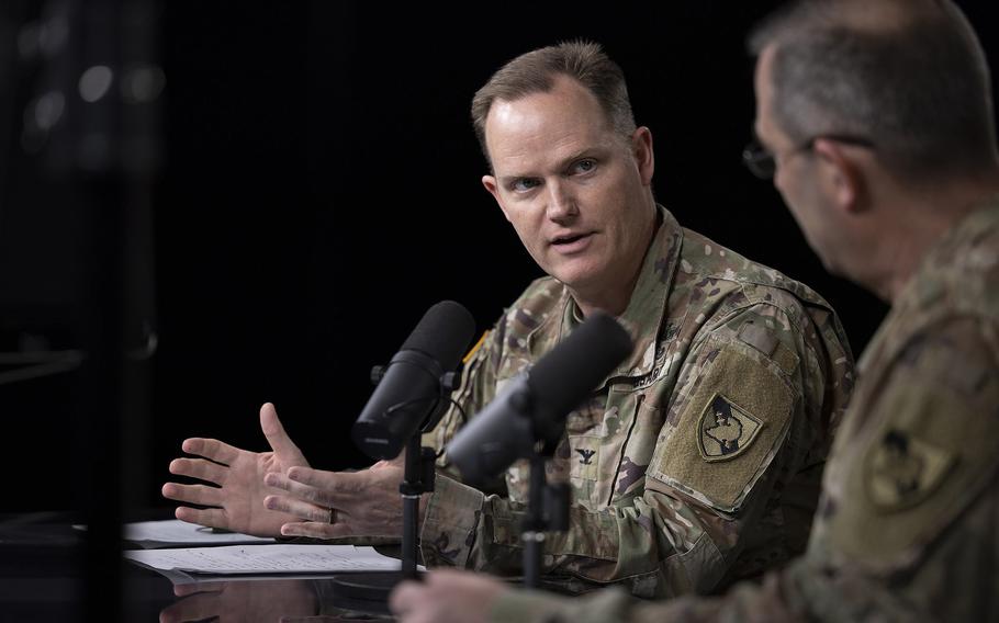 Wright in uniform and seated, speaking into a microphone during a podcast.