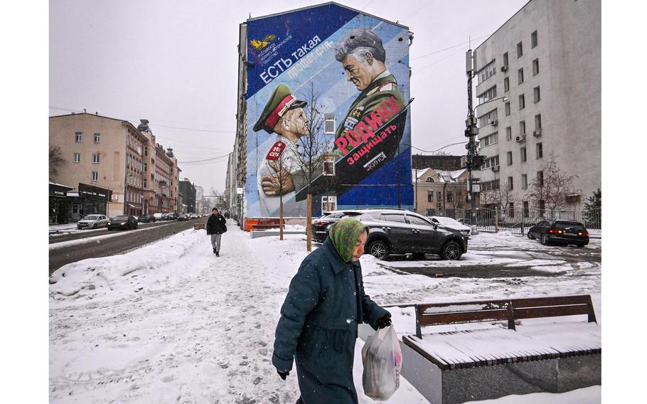A pedestrian walks past a mural depicting a Russian General and a cadet with a slogan reading “There is such a profession — to defend the homeland” in Moscow on Jan. 17, 2023. 