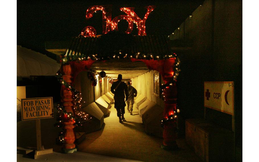 Soldiers make their way through holiday decorations Dec. 19, 2011, at the dining facility at Forward Operating Base Base Pasab in Kandahar province, Afghanistan. 