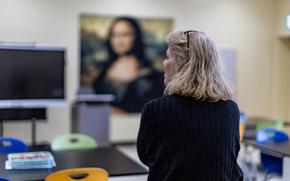 A woman looks at a classroom.