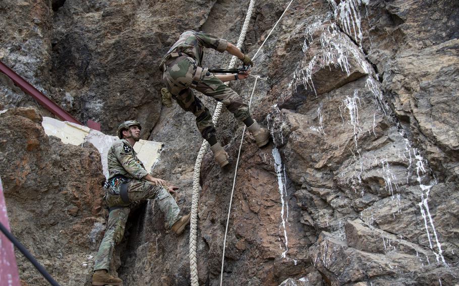 Staff Sgt. Christopher George, an instructor at the U.S. Army Mountain Warfare School, assists a French service member from the 5th Overseas Interarms Regiment with ascension techniques at the Arta Range Complex, Djibouti, Dec. 15, 2021.