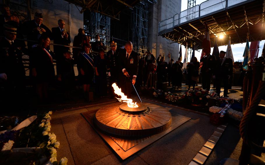 Gavin McIlvenna, president of the Society of the Honor Guard, Tomb of the Unknown Soldier, ceremonially rekindles the Eternal Flame in memory of the fallen at the Tomb of the Unknown Soldier at the Arc de Triomphe in Paris, Oct. 26, 2021. The Flame was first lit in 1923.