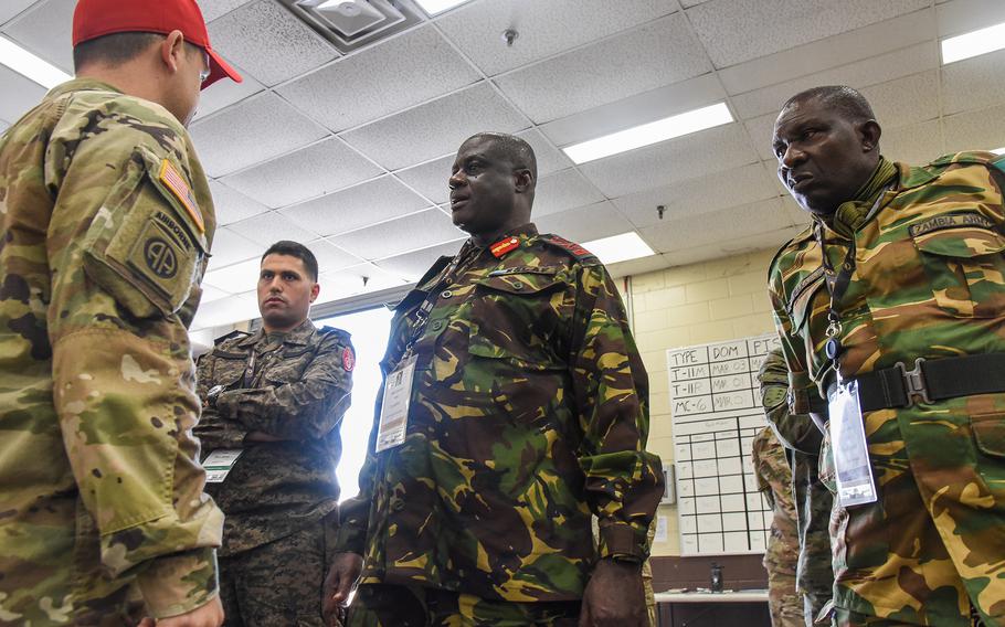 U.S Army Chief Warrant Officer 2 Wade Head, an airdrop systems technician with Fort Benning’s Airborne School, speaks March 22, 2022, with Sierra Leon’s Maj. Gen. Peter Lavahun, center, Zambia’s Warrant Officer 1 Sydney Mwakayaya, right, and a Tunisian military officer during the African Land Forces Summit at the Georgia Army post.