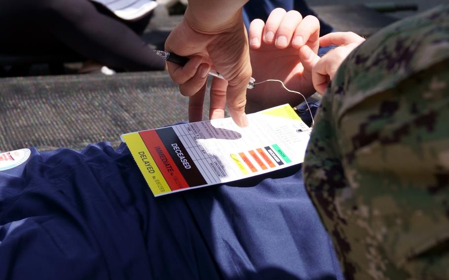 Actors taking part in an earthquake-response drill go through triage at Yokosuka Naval Base, Japan, Wednesday, May 17, 2023.