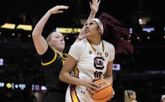 South Carolina center Kamilla Cardoso (10) drives around Iowa forward Addison O'Grady during the first half of the Final Four college basketball championship game in the women's NCAA Tournament, Sunday, April 7, 2024, in Cleveland. (AP Photo/Morry Gash)