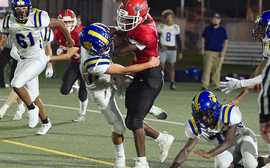 Kinnick's Trey Bennett pushes through Yokota defenders en route to scoring the first of his two touchdowns in the third quarter of the Red Devils home game against the visiting Panthers Friday. Sept. 30, 2022 at Berkey Field in Yokosuka, Japan. Yokota would hold on to win 21-20.